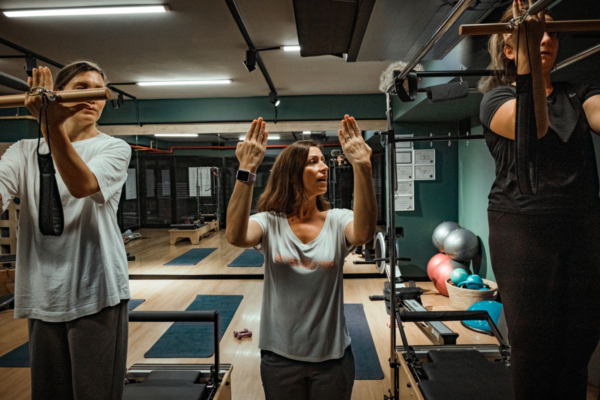 Pilates instructor leading a small equipment class in a studio